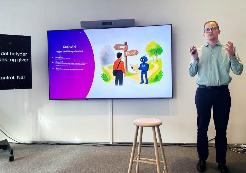 Presentation by Kristian Kappel from Siteimprove in front of a slide with an illustration of a human and a robot at a signpost reading “Doubt” and “Trust”, symbolizing trust and control in AI systems.